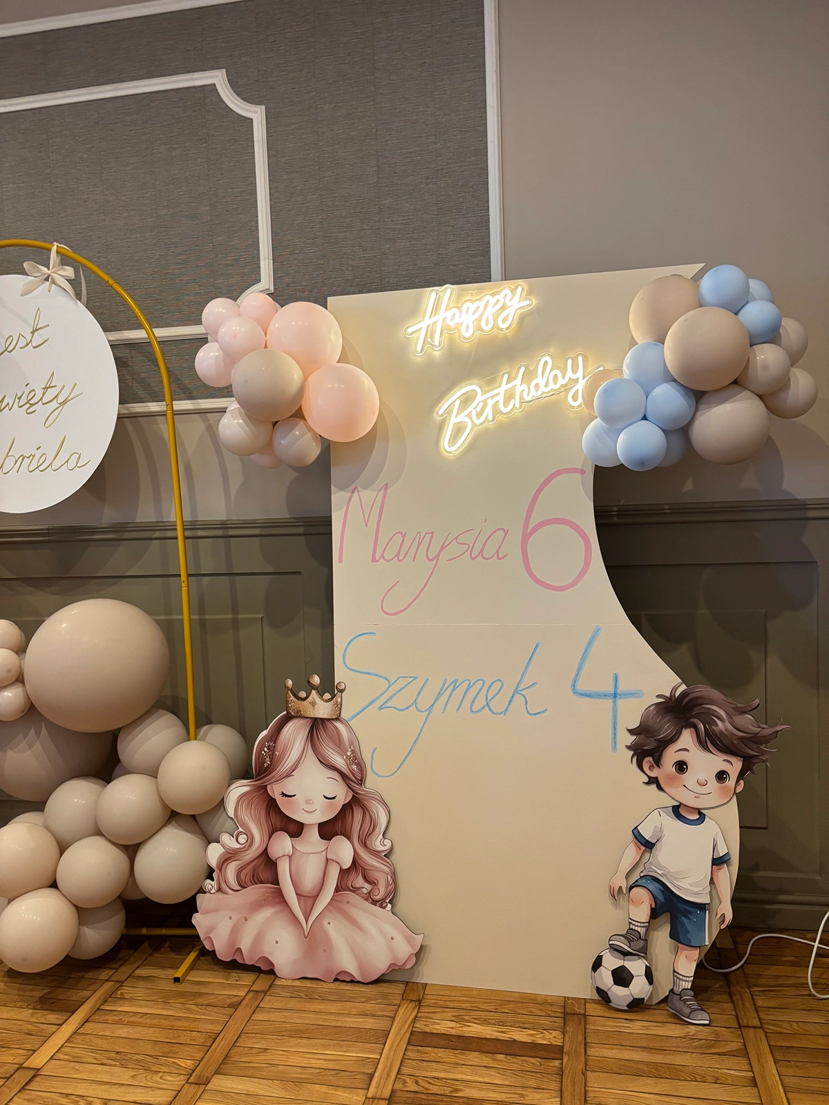 Ścianka urodzinowa z neonem Happy Birthday, napisami Marysia 6 Szymek 4 i postaciami księżniczki oraz piłkarza w Legionowie